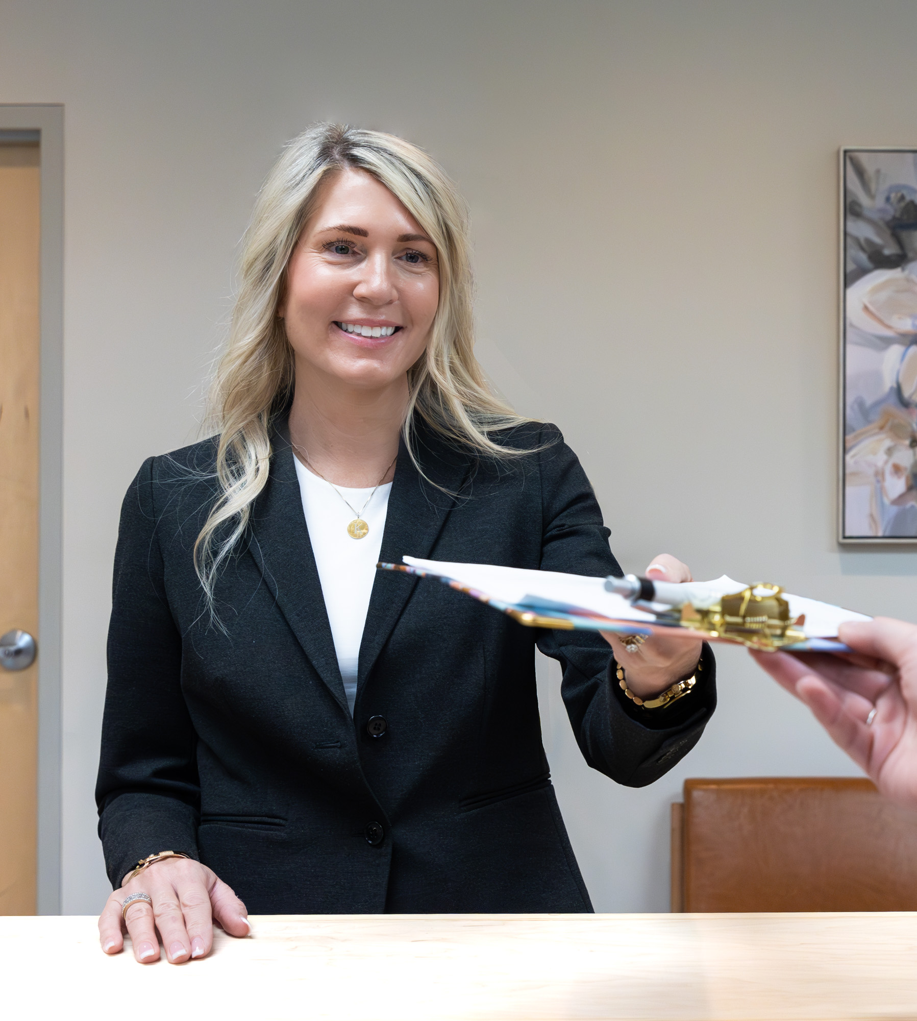 A team member welcoming a patient at the E. Michael Health front desk